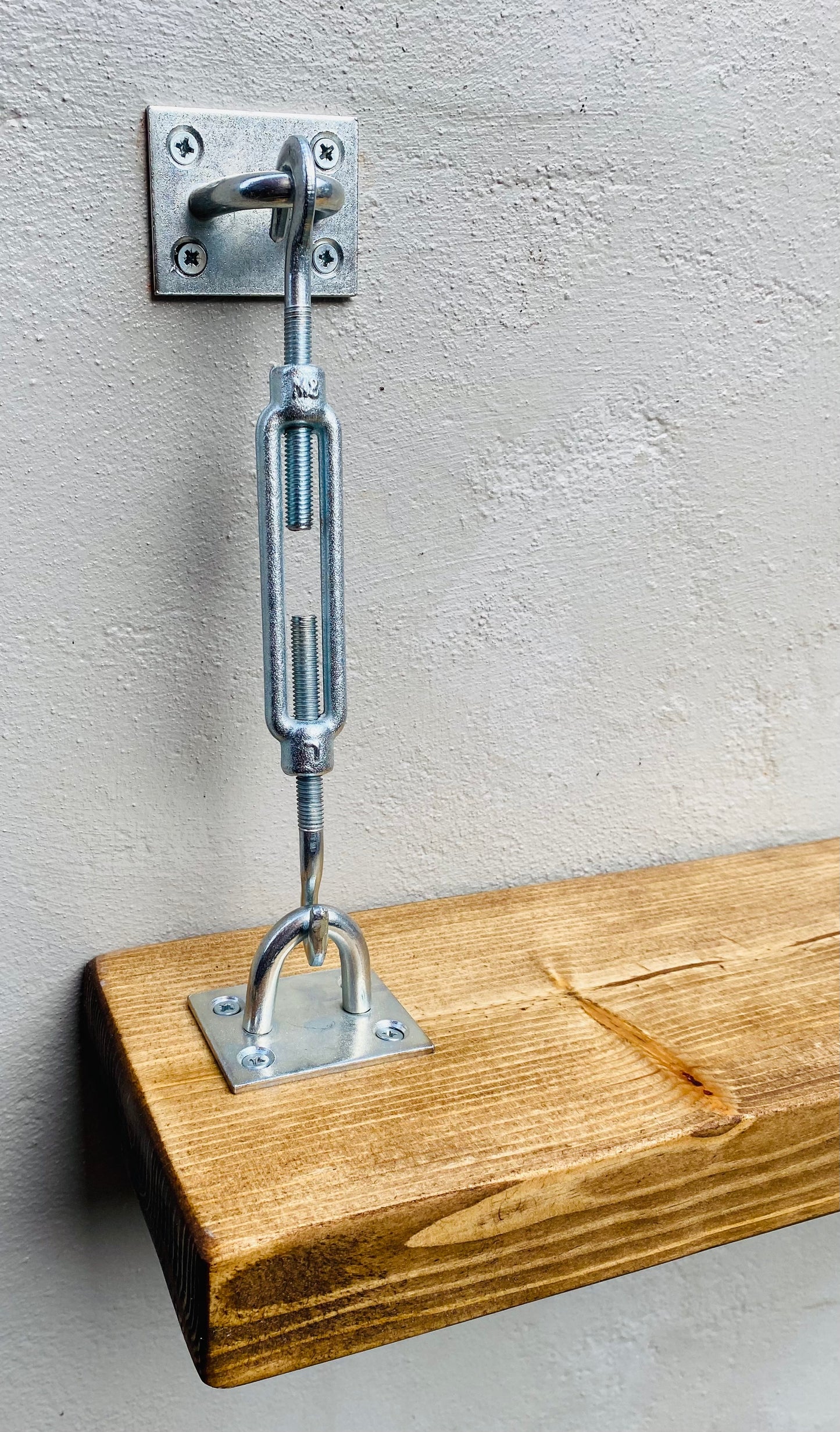 Close up of a turnbuckle shelf bracket wall mounted